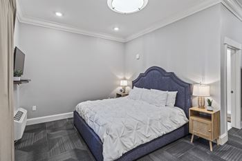 A white bedroom with a blue bed and white walls